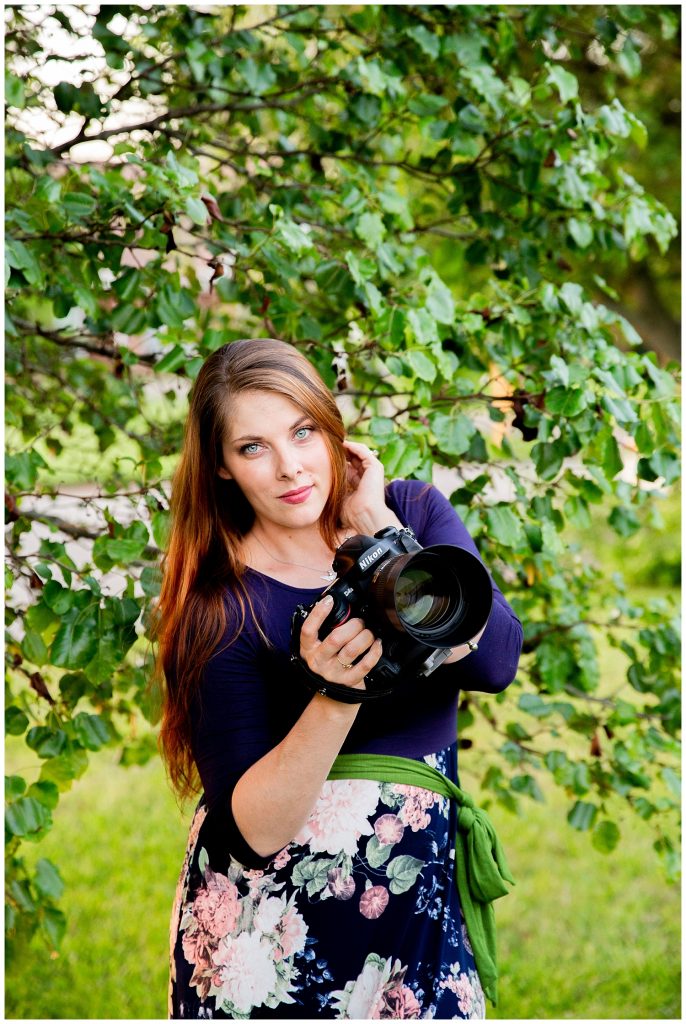 woman posing with camera near tree