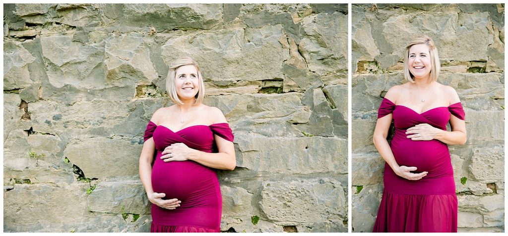 pregnant woman holding belly in front of rock wall