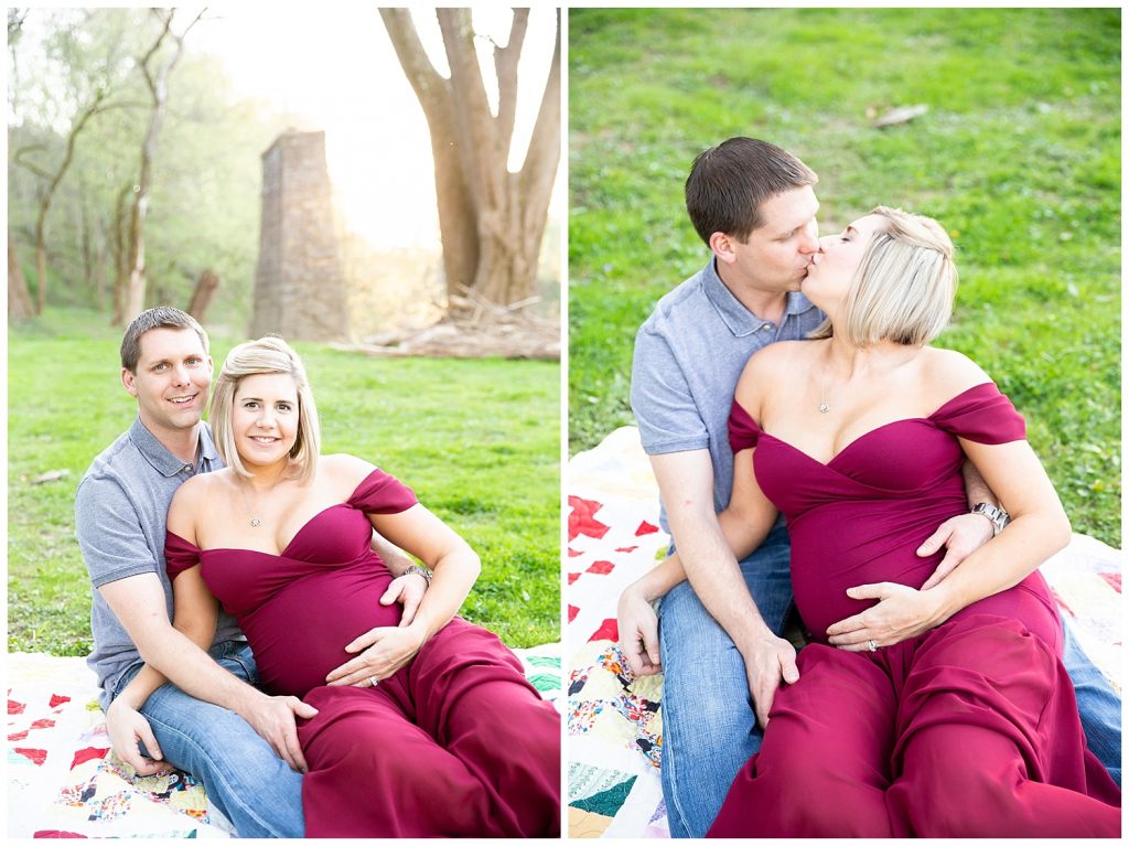 pregnant woman and man sitting on blanket kissing