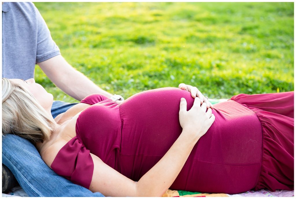 pregnant woman laying on man's legs
