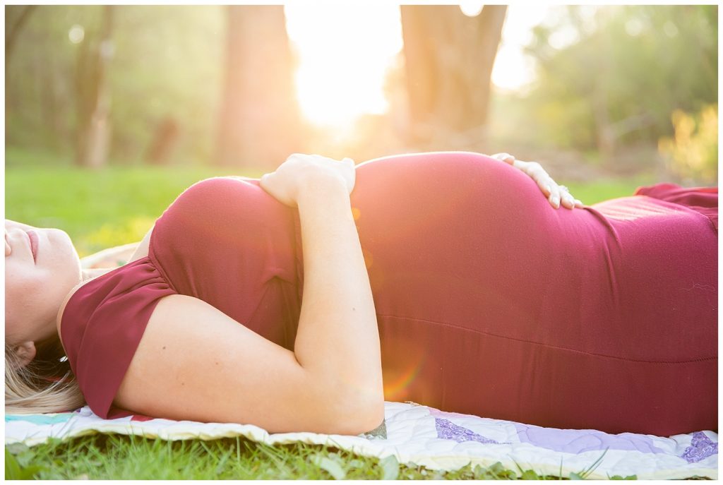 pregnant woman in red laying on ground