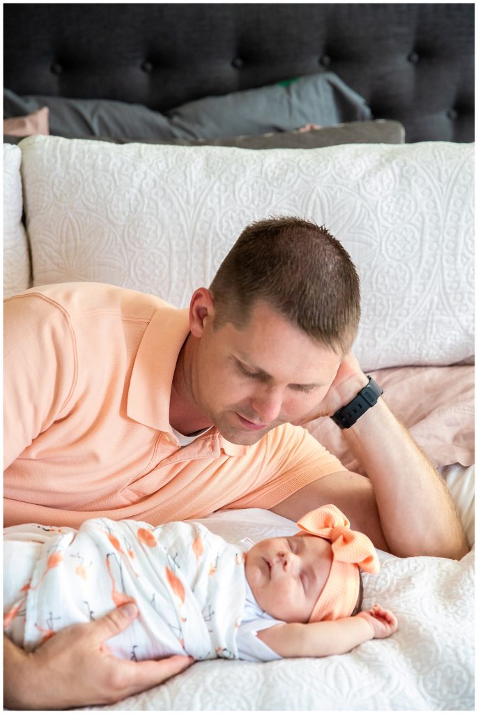 dad and baby girl laying on bed