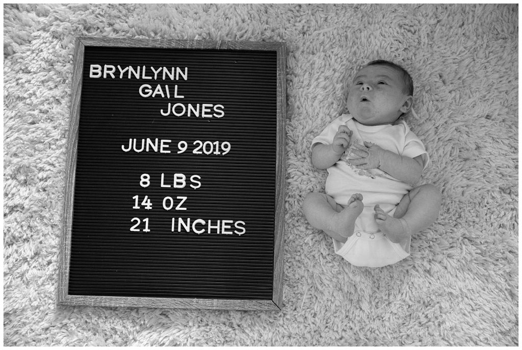 baby girl with letter board and birth stats