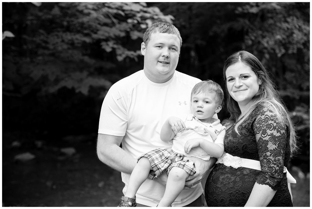 black and white of pregnant mom, little boy and dad