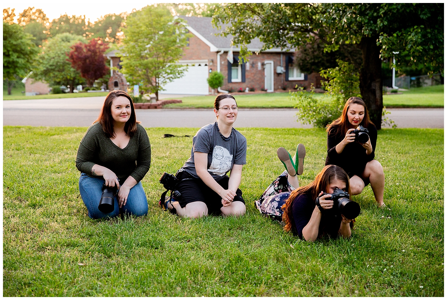 four woman sitting on ground with camera