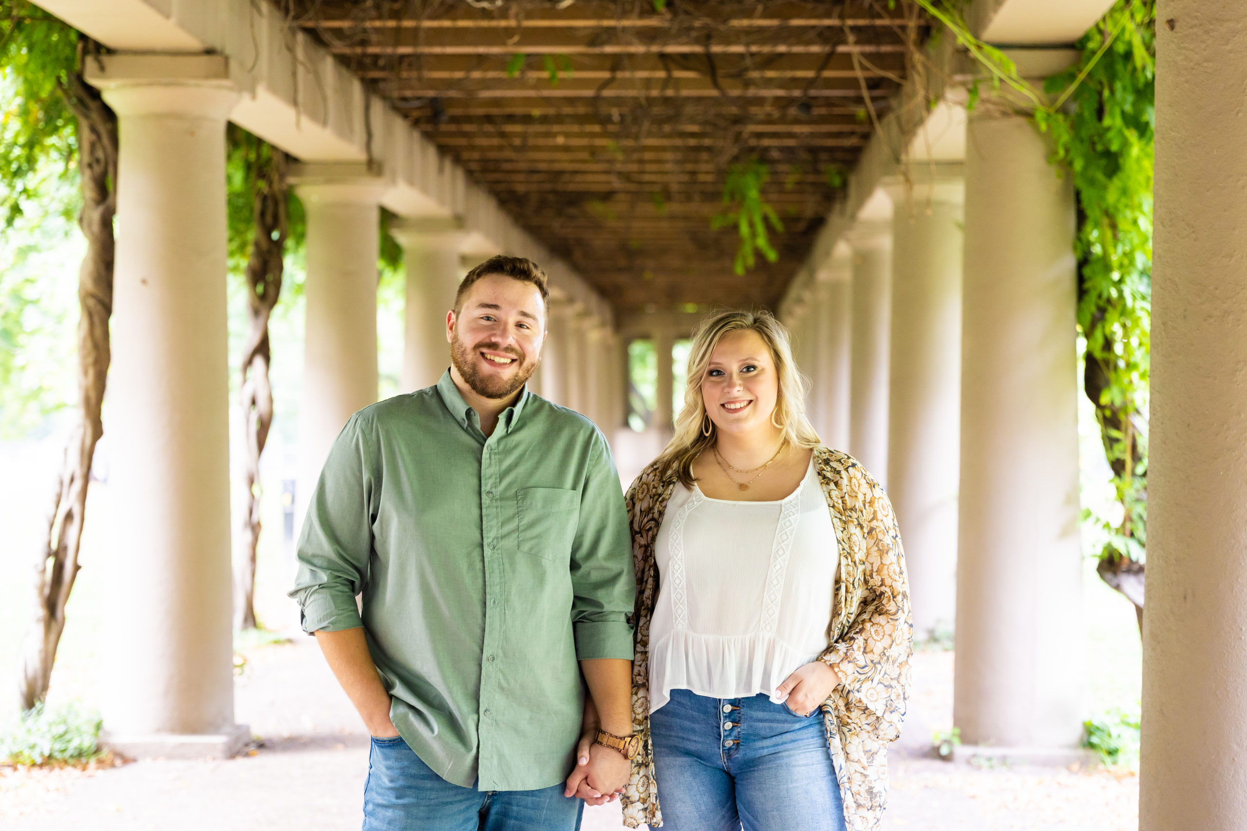A couple smiling during their engagement session at Central Park in Louisville, KY