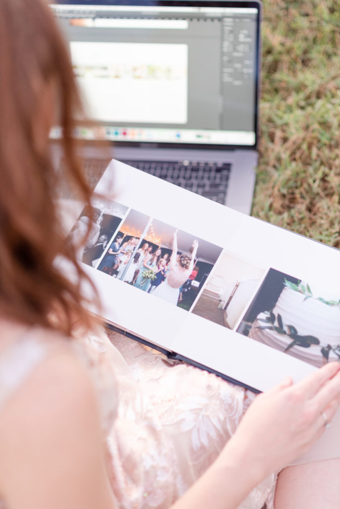 woman looking at wedding album and laptop
