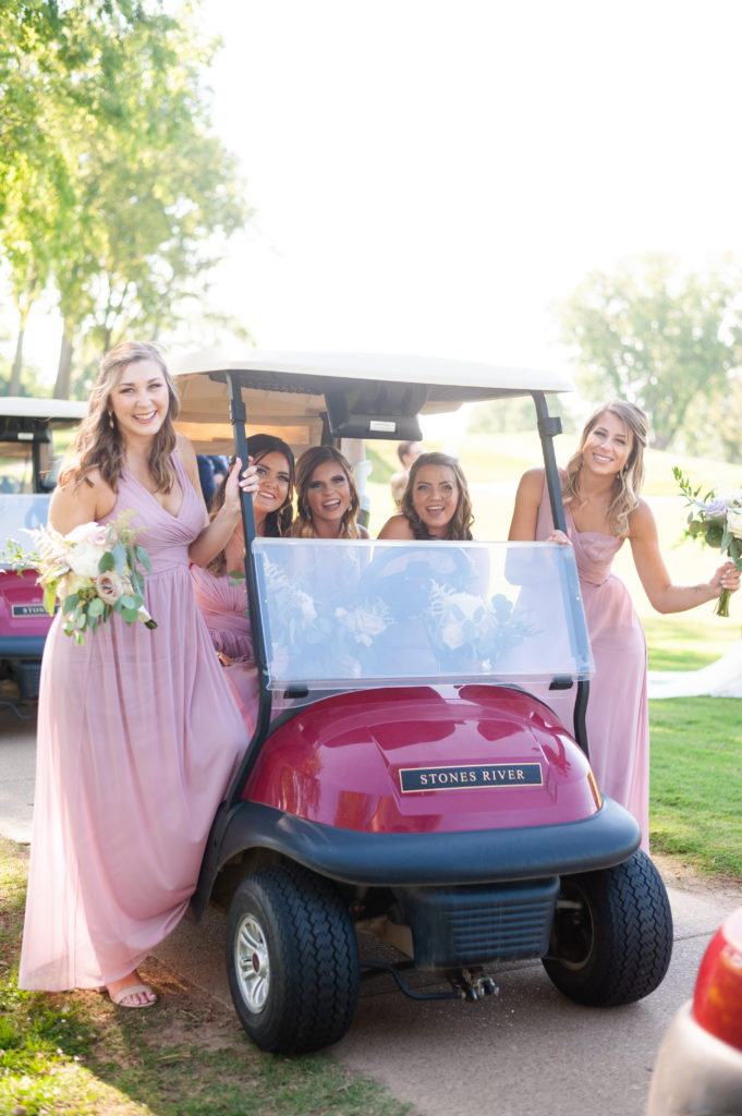 Bridesmaids standing in a golf cart