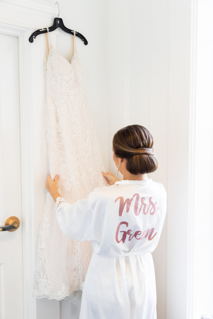 bride in robe getting ready and holding wedding dress