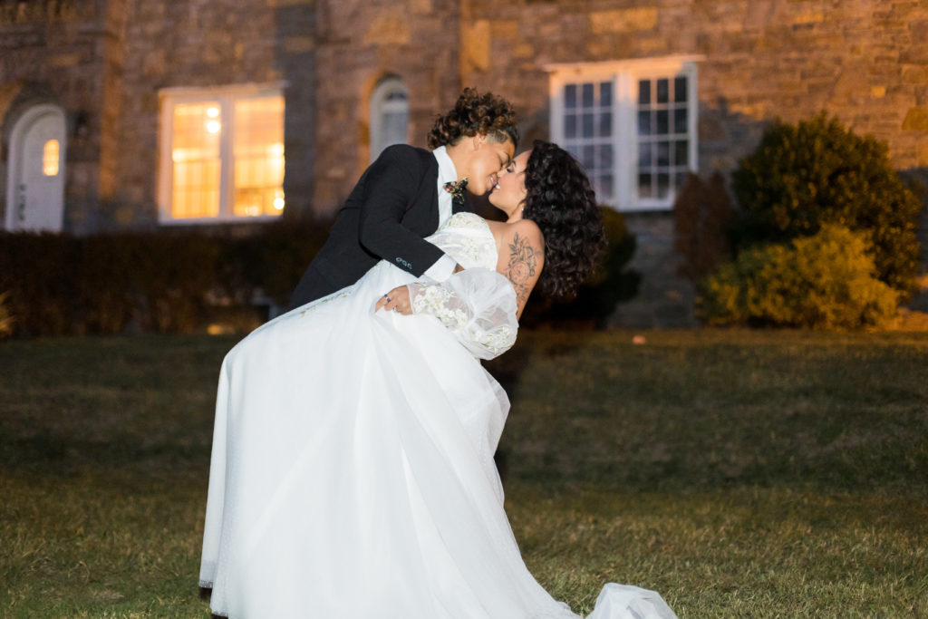 bride and groom kissing outside at night