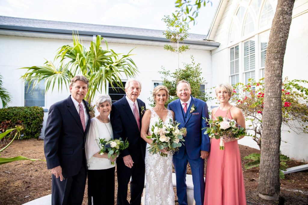 A bride and groom smile during their Anna Maria Island wedding with their family.